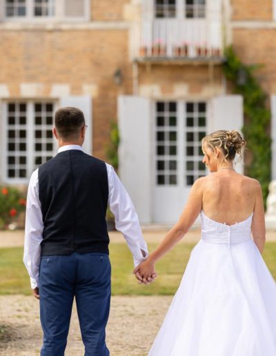 Mariés de dos se tenant la main devant le Château de Chaon (41), photographe mariage Sologne